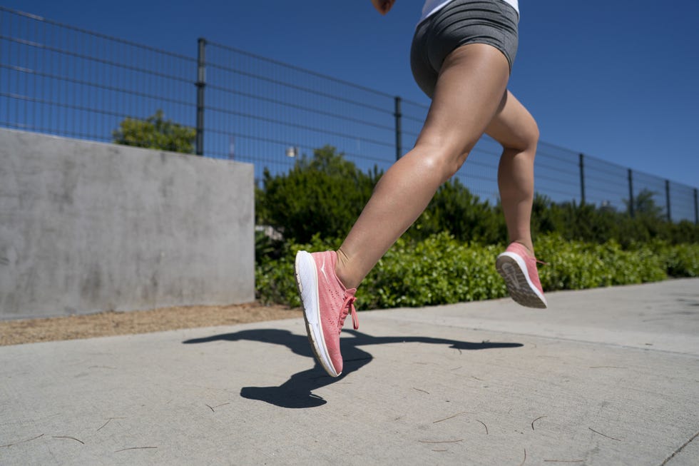 una atleta corriendo sobre el asfalto