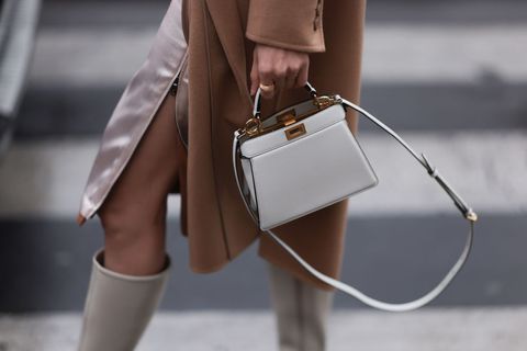 a model carries an unbranded leather bag to illustrate a roundup of the best summer 2023 bag trends