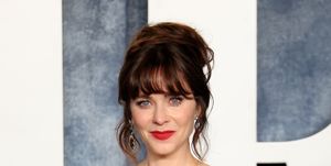 zooey deschanel on the red carpet in a detailed grey gown and up do hair