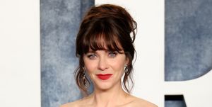 zooey deschanel on the red carpet in a detailed grey gown and up do hair