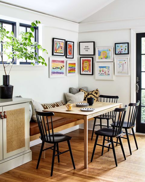breakfast nook, wooden dining table with black dining chairs, children artwork on walls, brown leather cushioned bench