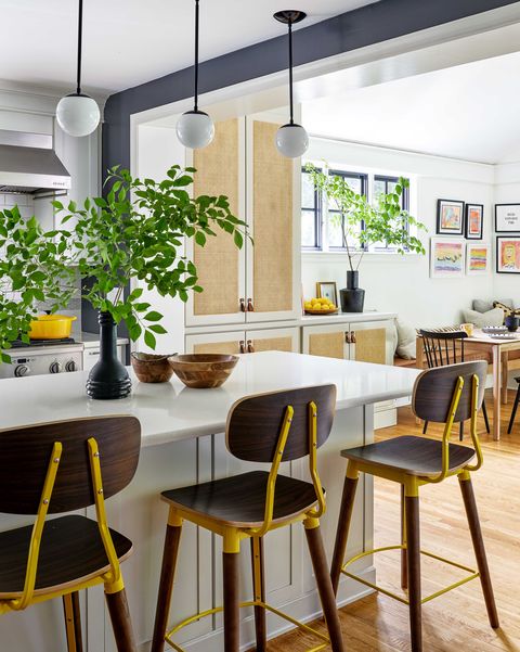 kitchen with light olive cabinets, dark brown and yellow bar stools