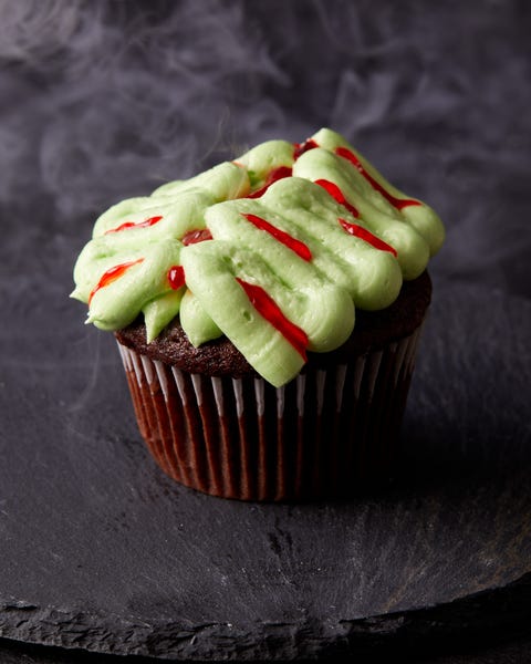 chocolate cupcakes decorated with green frosting and red gel food coloring to look like zombie brains