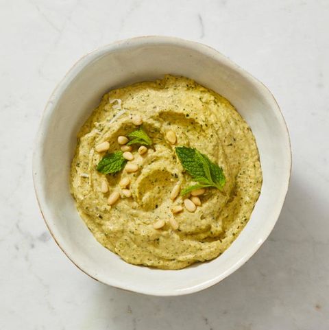 zucchanoush with mint leaves in a white bowl