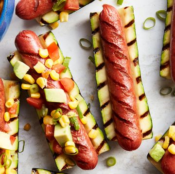 grilled hot dogs in between grilled zucchini topped with avocado salsa