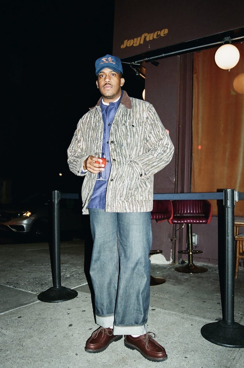 individual standing outside a venue holding a drink