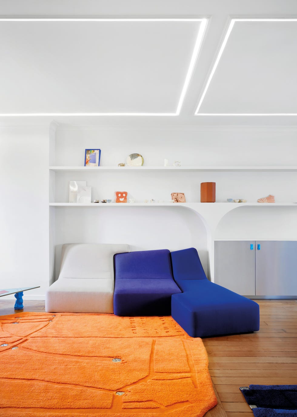 white living rom with blue sofa and orange rug