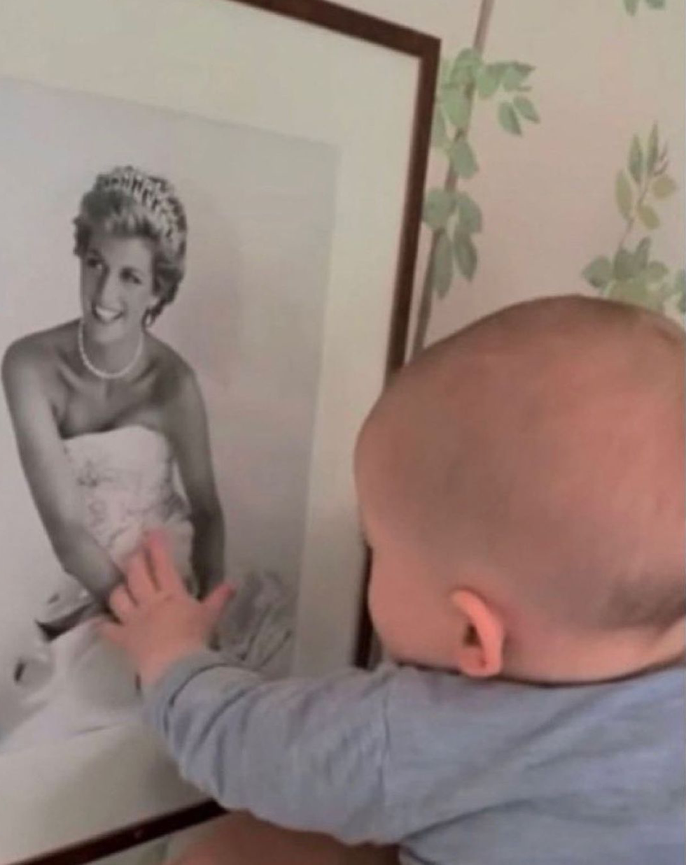 a baby looking at a painting