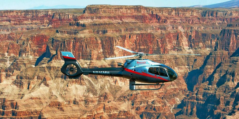 a helicopter flying over a canyon