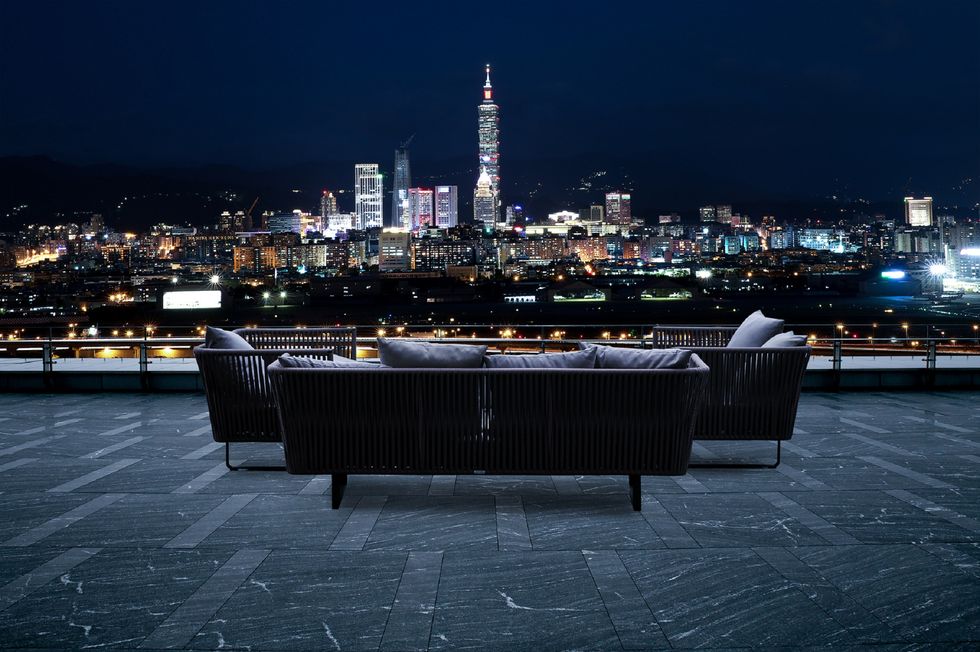 a table and chairs on a rooftop overlooking a city at night