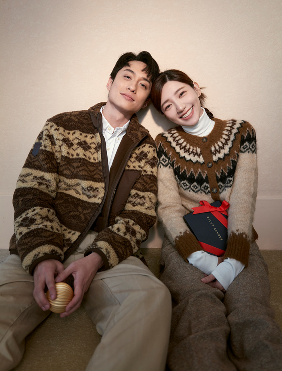 a man and woman sitting on a couch and smiling