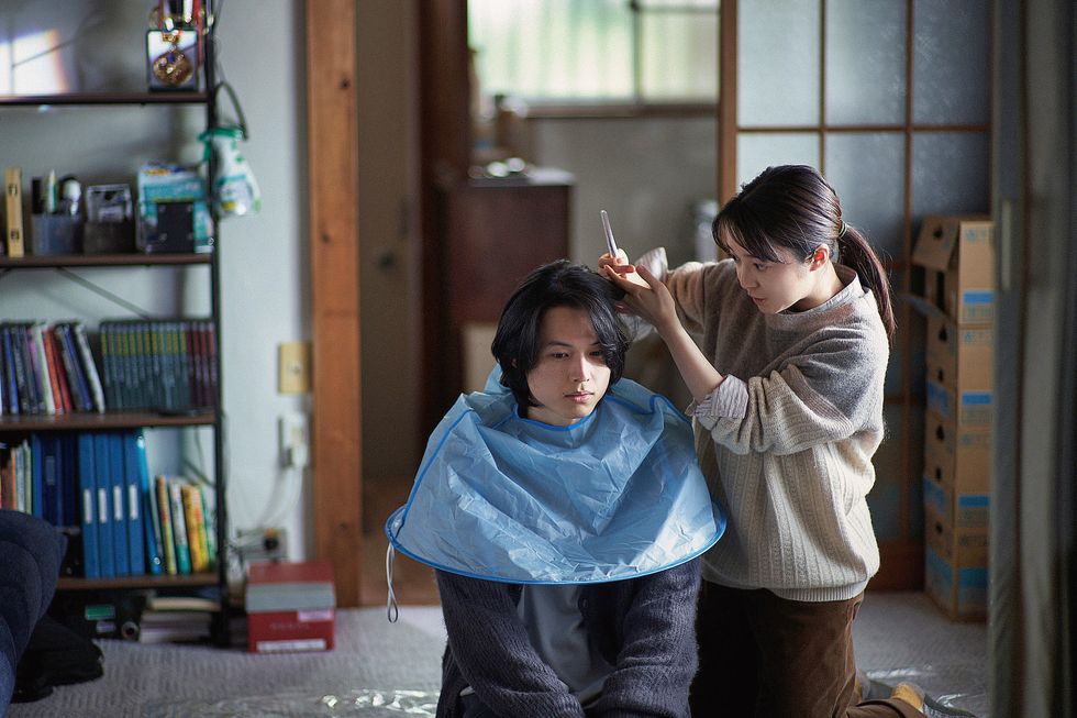 a person cutting another woman's hair