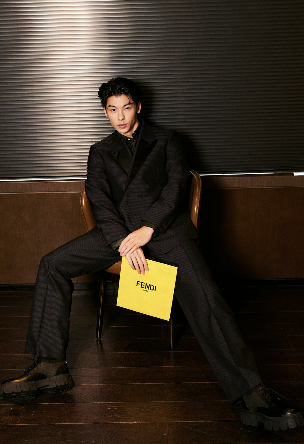 a person sitting on a chair holding a yellow box