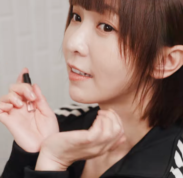 person applying a beauty or skincare product using a bottle
