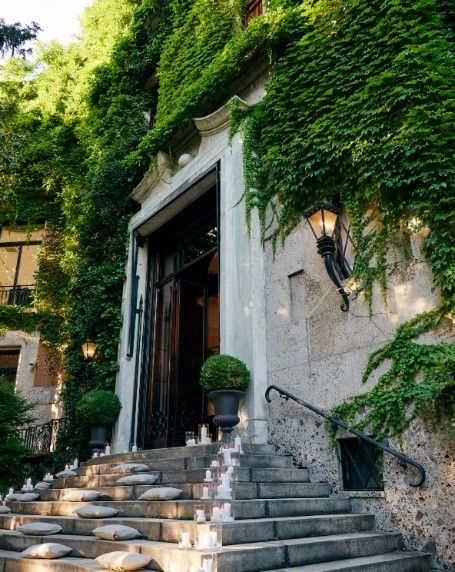 a stone building with stairs and plants
