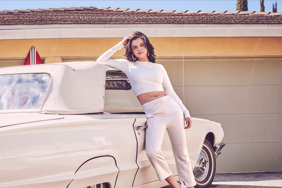 Selena Gomez穿上PUMA Cali櫻花粉球鞋靠在車子旁，完全藏不住鄰家女孩氣息。