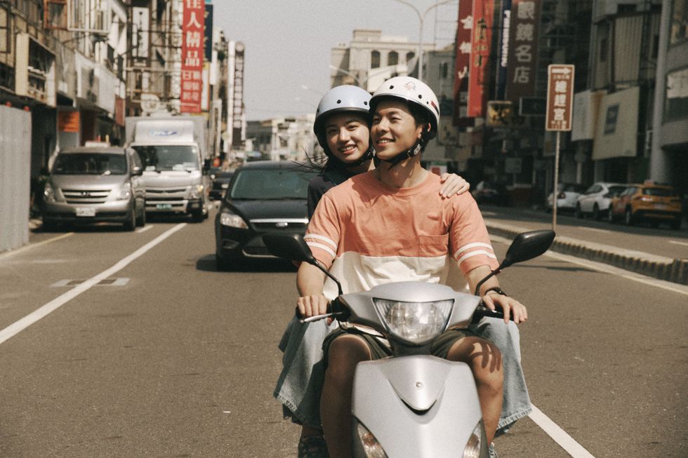a man and a woman riding a scooter