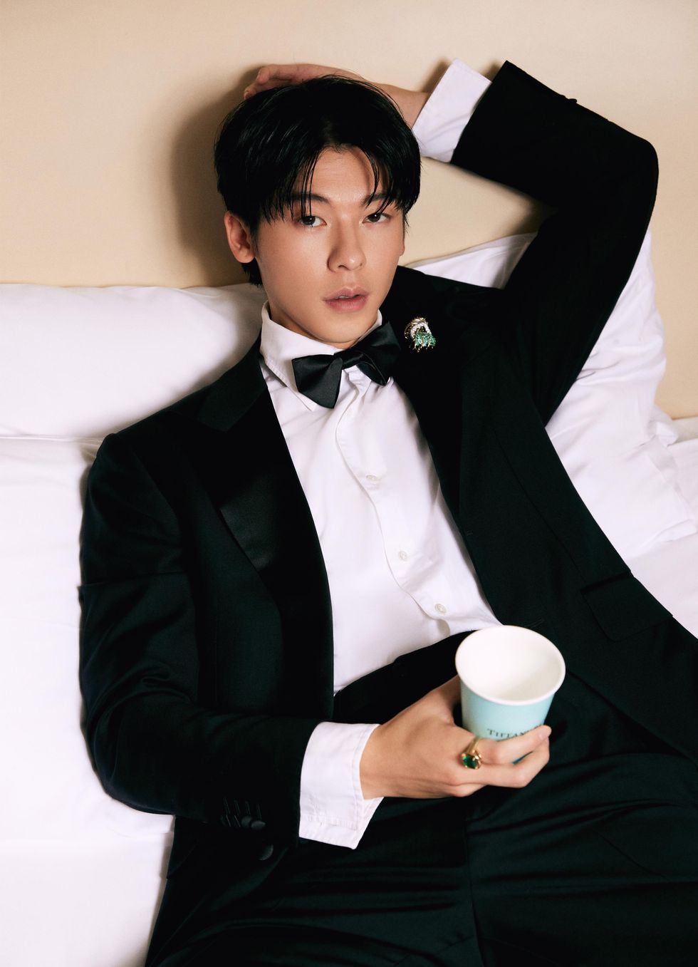 a person in a tuxedo holding a cup