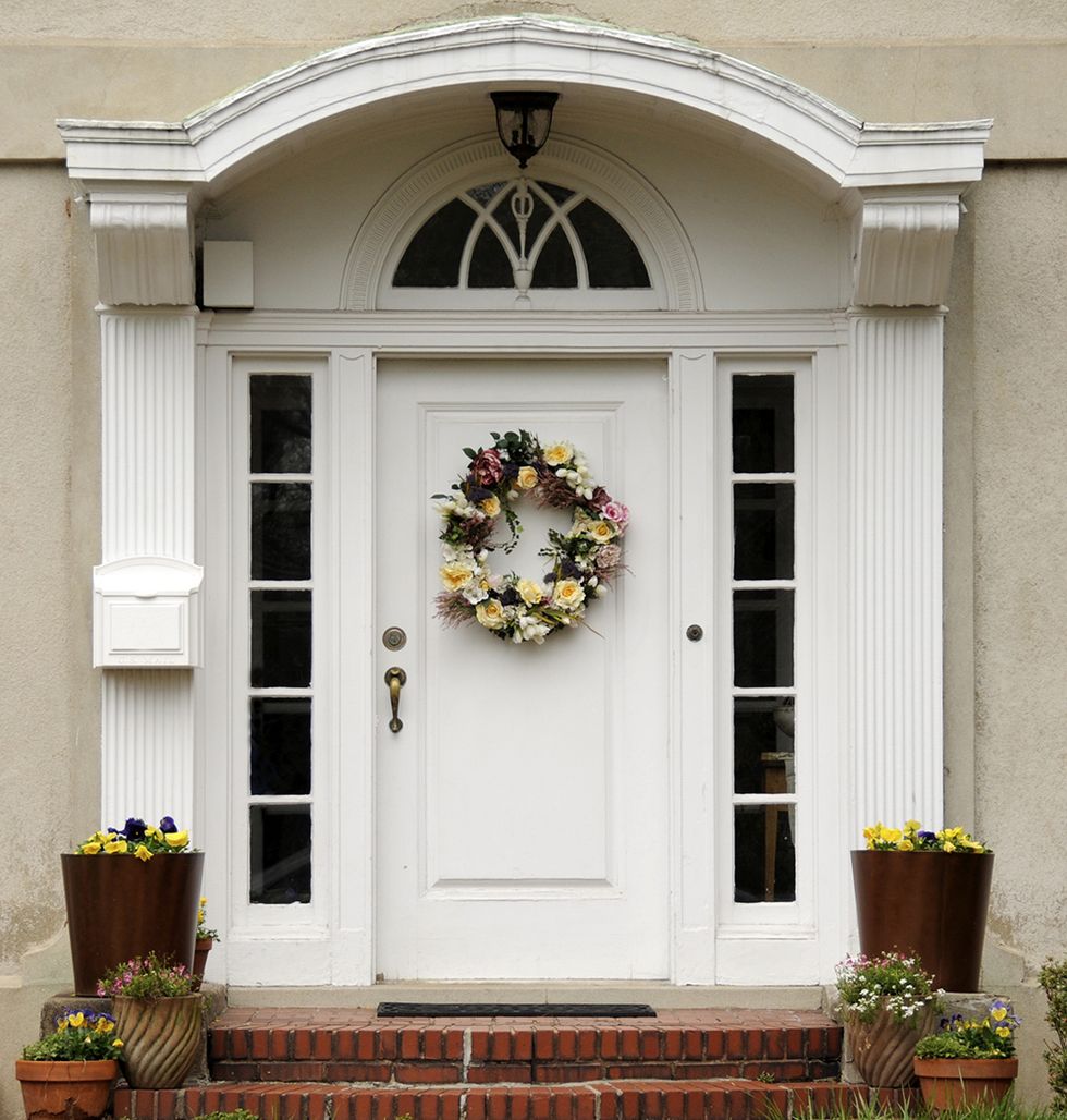 Flowerpot, Door, Home door, House, Fixture, Wreath, Door handle, Houseplant, Molding, Symmetry, 