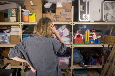 Woman attempting to search through a messy and cluttered garage