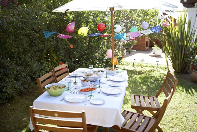 Outdoor dining table set out in garden before a family birthday celebration.