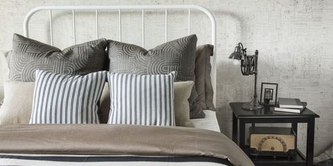 Striped and patterned monochrome pillows and blanket on bed