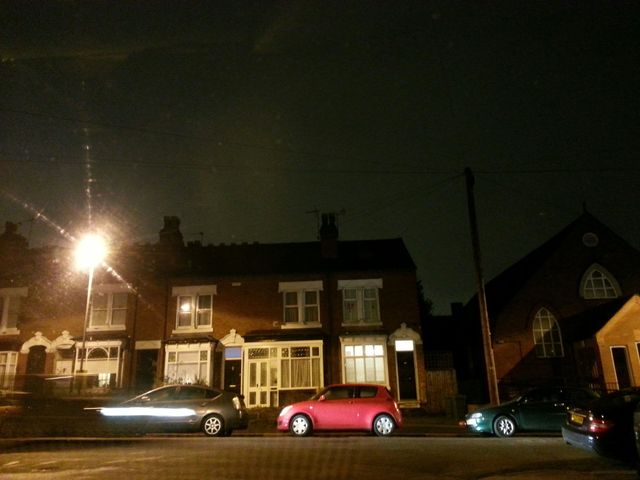Cars Parked On Street Outside House At Night