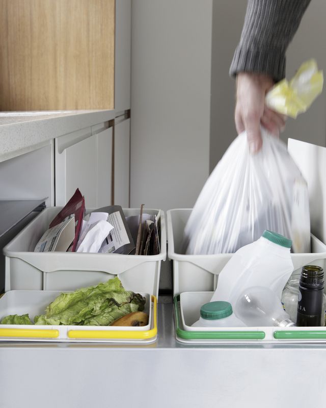 person removing rubbish bag from waste and recycling drawer