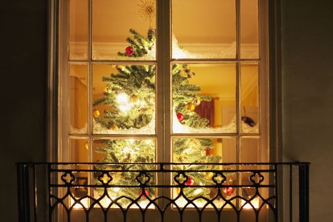 Christmas ornaments on tree behind window