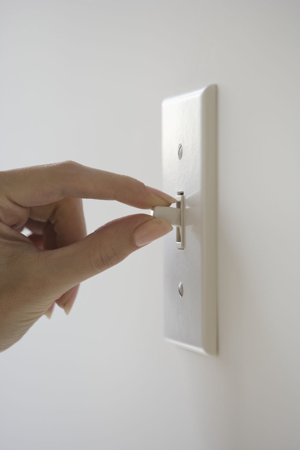 Close up of woman turning light switch