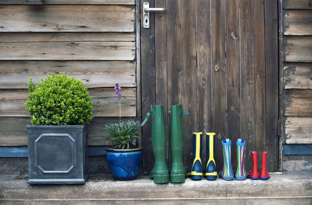 wellington boots neatly lined up in front of garden shed