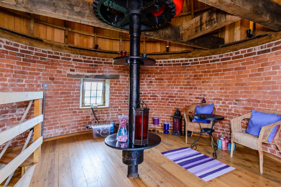 Brick interior walls inside windmill home with purple and wooden decor