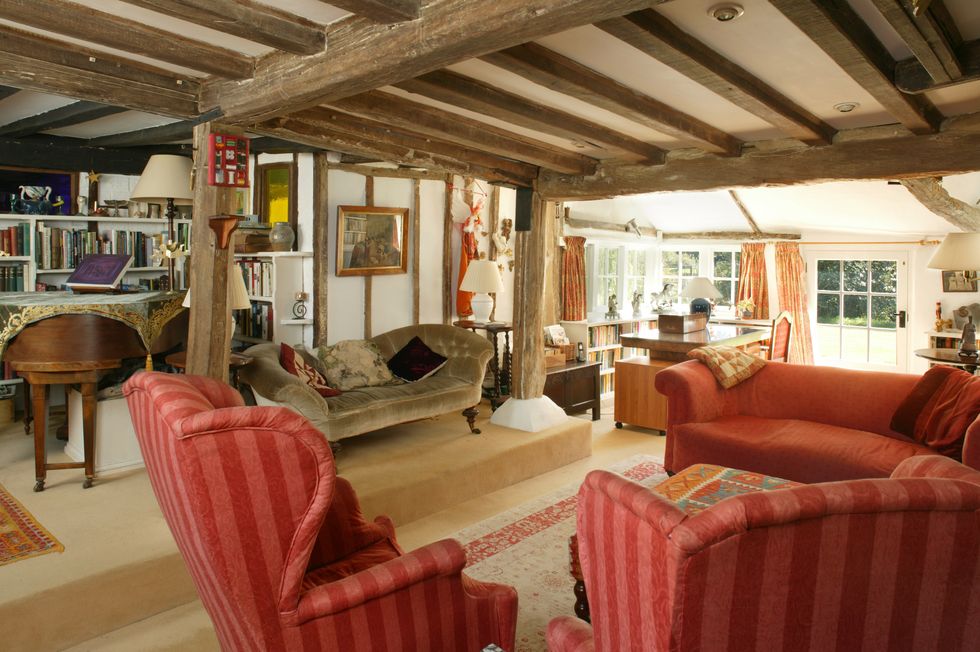 Interiors of Cotchgord Farm with red sofas and wood beam ceilings