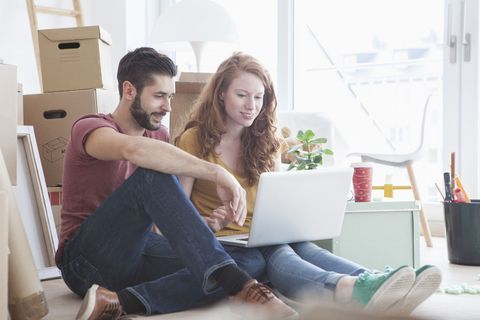 Young couple in new flat with cardboard boxes
