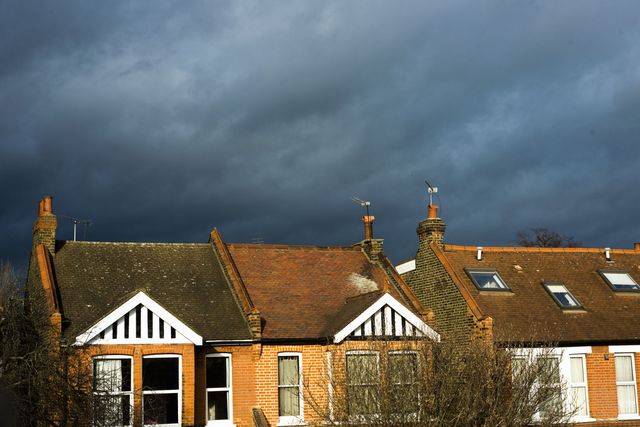 Threatening clouds over sun lit houses