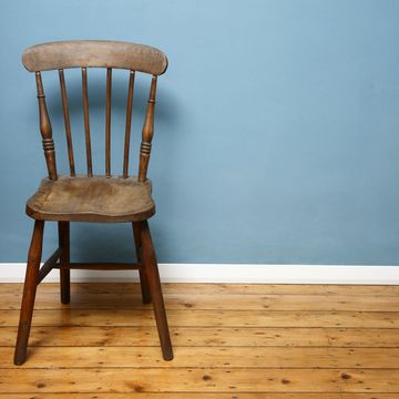 Bare wood flooring with wooden chair and blue walls