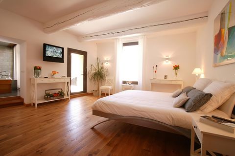 Bedroom with wooden floors and a TV