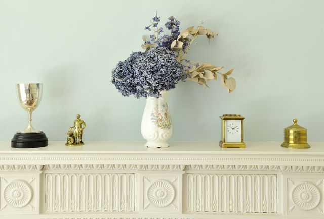 Mantelpiece with a vase of flowers and trinkets
