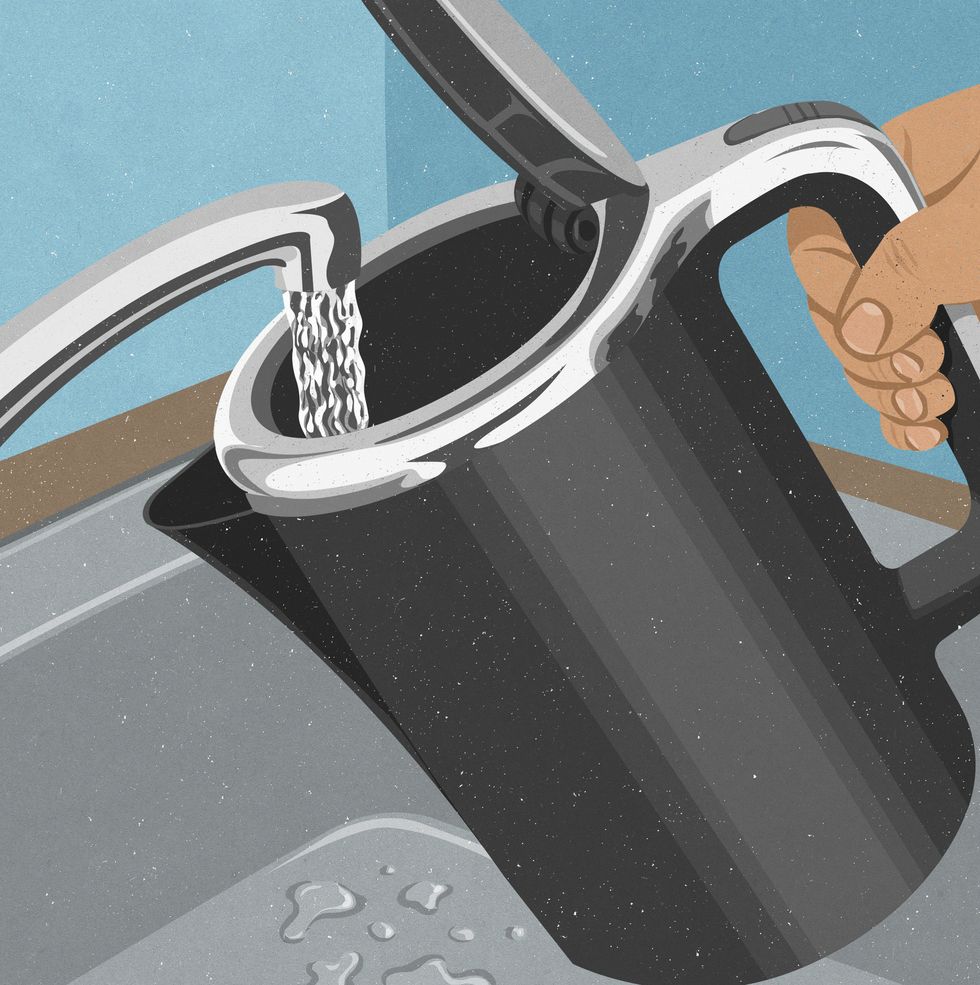 Hand filling kettle with water from faucet