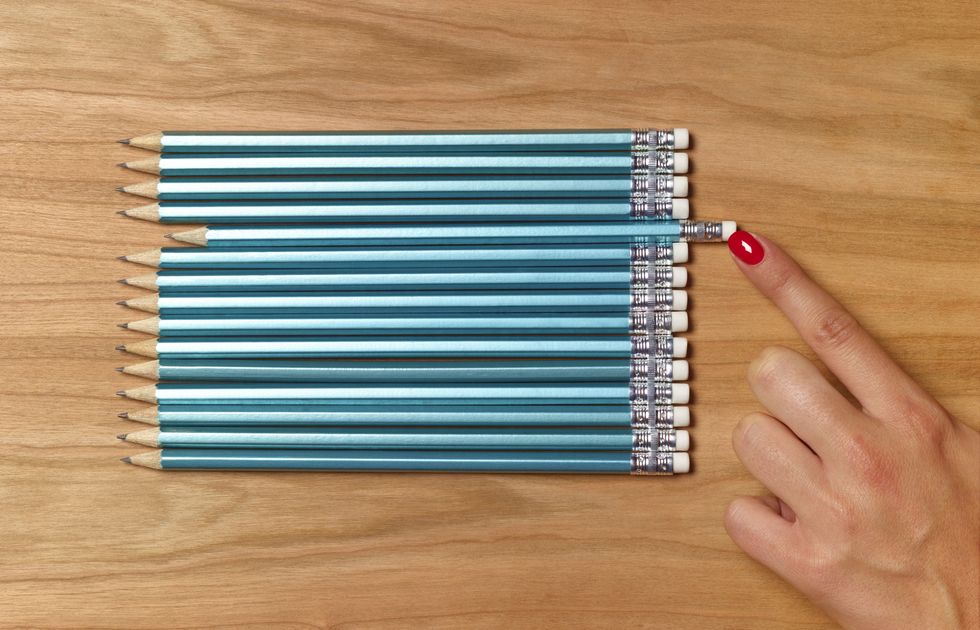 Blue pencils organised neatly on wooden table