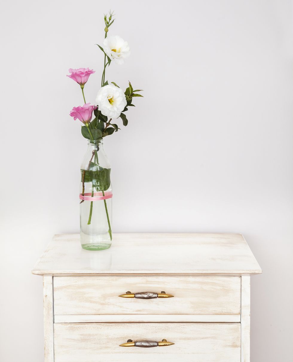 Recycled forniture with lisianthus flower bouquet against white wall