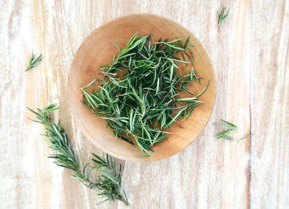 Top View Of Fresh Rosemary In Bowl On Wooden Table