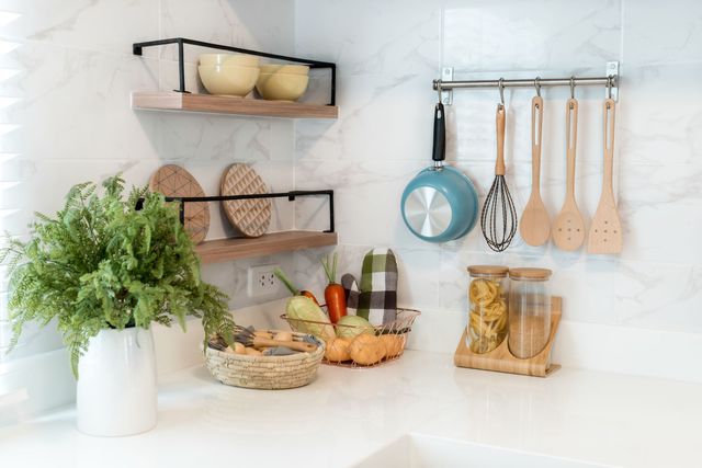 Kitchen wood utensils, chef accessories. Hanging copper kitchen with white tiles wall