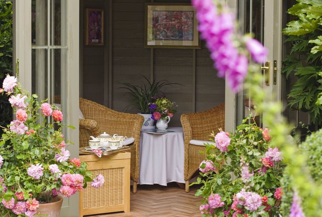 Summerhouse with wicker furniture and afternoon tea set, June
