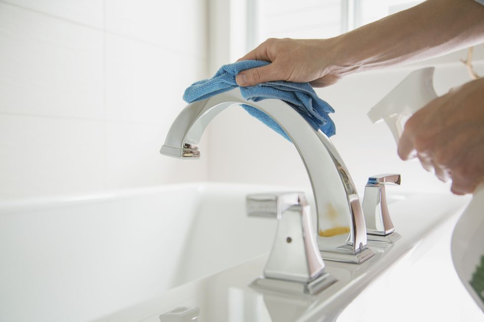 Woman polishing bathroom fixture