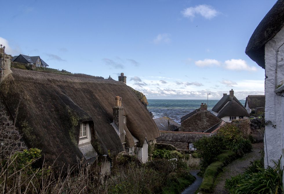Cadgwith fishing Village in Cornwall: A very quaint fishing village with thatched roof cottages so pretty, these houses are seen on the walk down the hill to get to the village