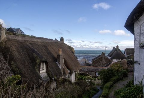 Cadgwith fishing Village in Cornwall: A very quaint fishing village with thatched roof cottages so pretty, these houses are seen on the walk down the hill to get to the village