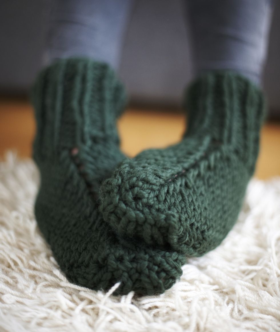 Pair of feet in green knitted socks