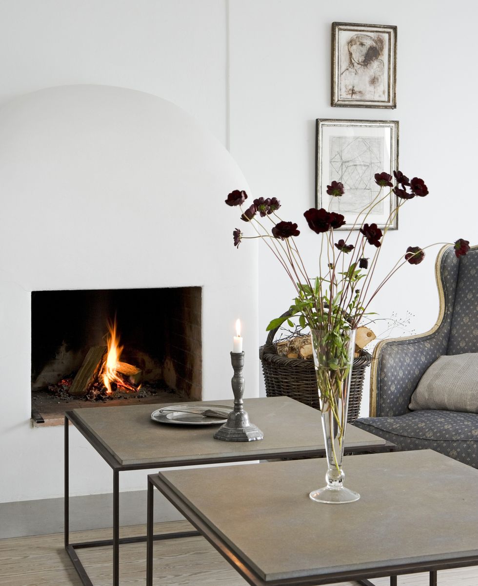 Flower arrangement on coffee table in front of simple fireplace in modern sitting room