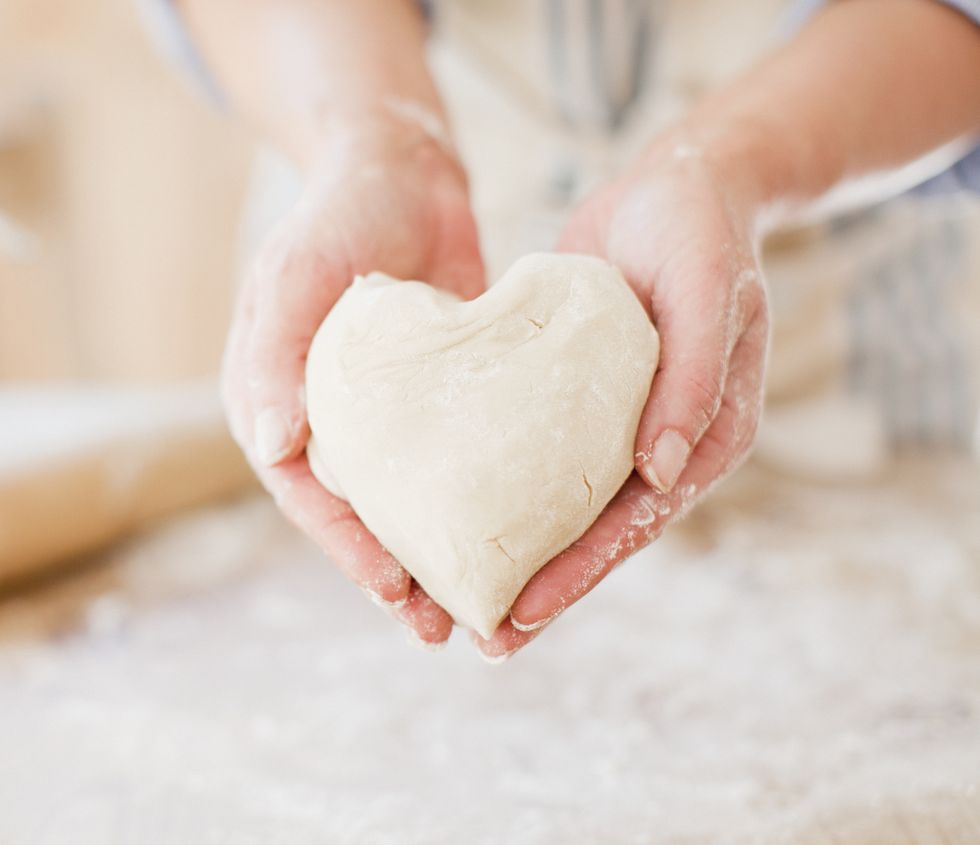 Close up of woman holding heart-shape dough
